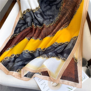 Dettaglio della sciarpa di seta con motivi a catena dorata e stampe leopardate moda