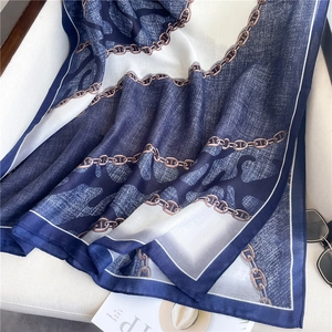 Dettaglio della sciarpa in seta con motivo a catena blu navy e tie-dye su sfondo strutturato