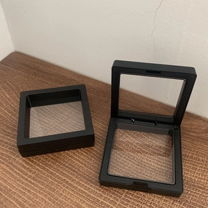 Black square PE film floating jewelry display box for rings and necklaces on wood surface