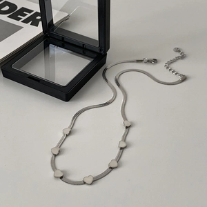 Close-up of silver heart snake chain necklace with lobster clasp and adjustable link