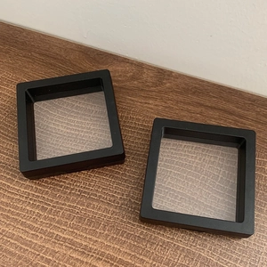 Dual square black PE film jewelry display boxes for earrings and rings on wood table