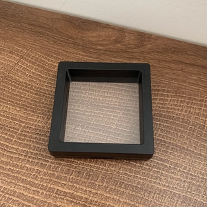 Macro shot of black PE film floating display case for jewelry and coin storage