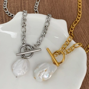 Vue macro d'un collier de perles baroques avec chaîne en métal et fermoir à bascule OT