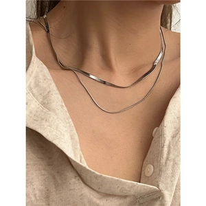 Close-up of double layered flat snake bone chain necklace in polished silver titanium steel