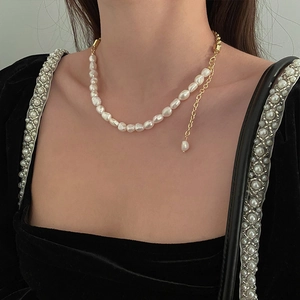 Collier élégant perles de culture baroques et chaîne dorée sur mannequin en velours