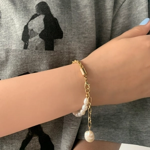 Vue détaillée d'un bracelet de perles baroques fait main avec chaîne dorée et fermoir