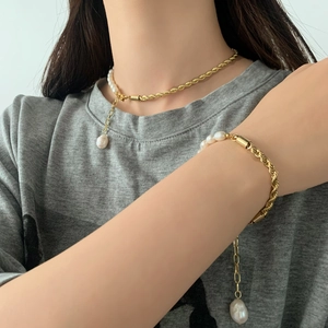 Détail du collier chaîne torsadée dorée avec perles baroques et pendentif goutte