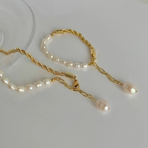 Gros plan du bracelet perle baroque et chaîne torsadée dorée avec fermoir réglable