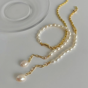 Gros plan d'un collier de perles d'eau douce baroques avec chaîne torsadée dorée