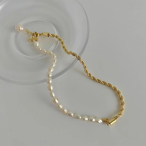 Détail macro de perles d'eau douce baroques et chaîne torsadée dorée avec fermoir
