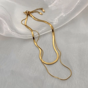 Close-up of a double-layered gold snake chain necklace with an adjustable extender chain