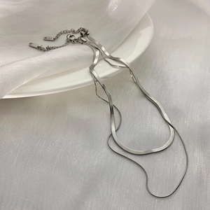 Detailed macro view of silver double-layered snake chain necklace with lobster clasp