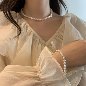 Gros plan d'un ensemble élégant collier et bracelet en perles d'eau douce baroques