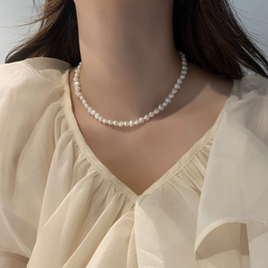 Collier élégant en perles d'eau douce irrégulières porté par un mannequin femme