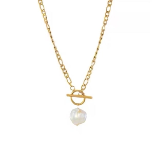 Collier perle baroque avec chaîne Figaro dorée et fermoir à bascule sur fond blanc