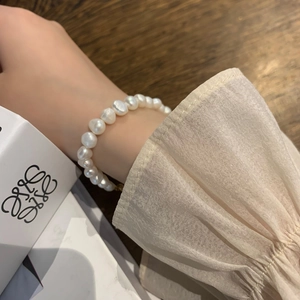 Détail d'un bracelet en perles d'eau douce baroques avec fermoir doré au poignet