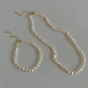 Vue détaillée de l'ensemble collier et bracelet en perles d'eau douce baroques et fermoir doré