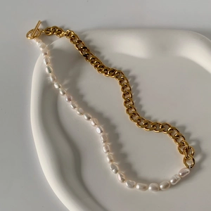 Detailansicht der goldenen Panzerkette und Barockperlenkette mit Vintage-Knebelverschluss
