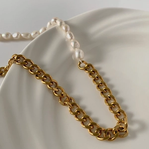 Detailansicht einer Barockperlen-Halskette mit goldener Gliederkette auf weißem Tablett