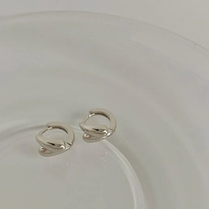 Macro view of silver water drop earrings with a modern twisted metal structure design