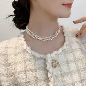 Detailed close-up of a three-layer freshwater pearl choker necklace on a model