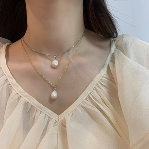 Close-up of elegant double layered teardrop pearl necklaces on gold and silver chains