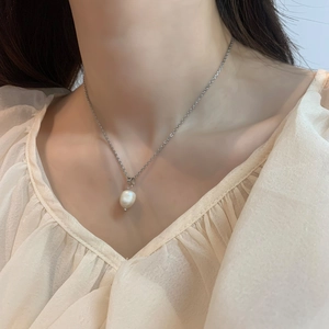 Close-up of elegant baroque freshwater pearl pendant on a delicate silver chain necklace
