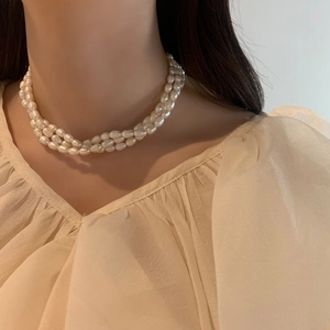 Detailed close-up of a triple-strand freshwater pearl necklace with an elegant cream glow