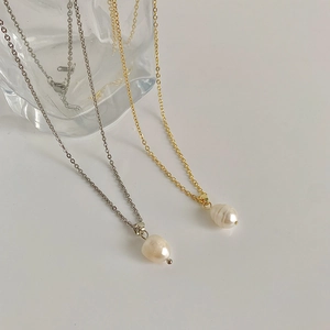 Detailed view of baroque freshwater pearl pendant on a thin gold and silver chain