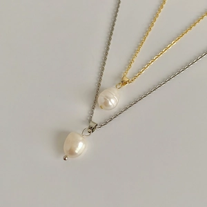 Detailed shot of baroque freshwater pearl necklaces in gold and silver metal finishes