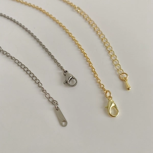 Detail of gold and silver lobster clasps with adjustable extension chains for necklaces