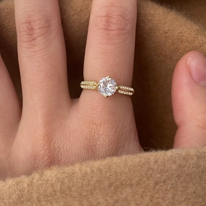 Elegant gold ring with large round zircon and pavé diamonds shown on hand