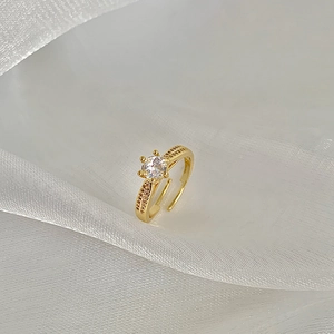 Detail of adjustable gold ring featuring a six-prong round zircon and micro-pave accents
