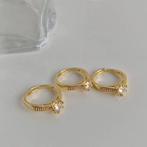 Detailed macro view of three gold crown rings with large zircons and pavé settings