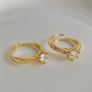 Macro shot of gold-plated rings featuring a large round zircon and sparkling pave side stones