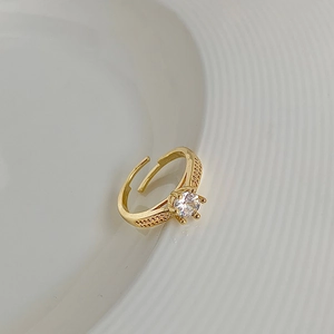 Close-up of gold adjustable ring with four-prong set round zircon and pave side stones