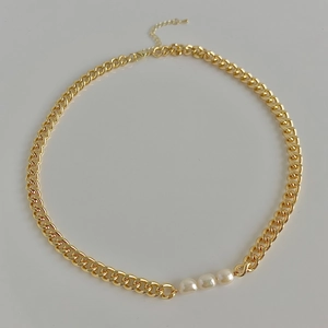 Gold-plated Cuban chain necklace featuring three freshwater baroque pearls on white background