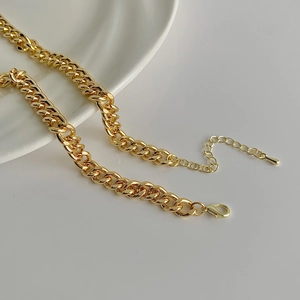 Detail of gold curb chain necklace with secure lobster clasp and adjustable extension link