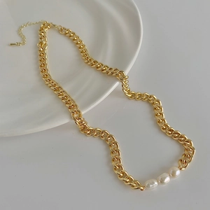 Detail of gold curb chain necklace featuring three freshwater pearls and adjustable clasp