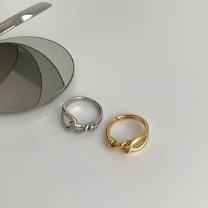 Minimalist geometric knot rings in gold and silver finish on white background