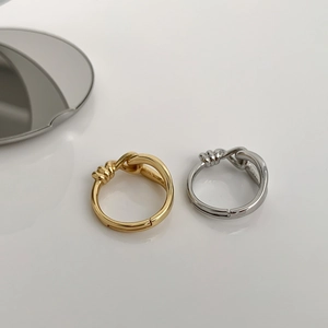 Detail of knotted geometric open rings in gold and silver finish with adjustable bands