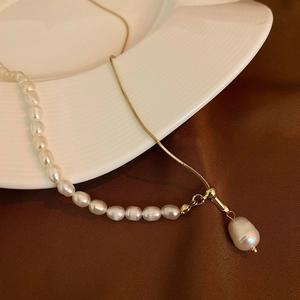 Detailed macro view of a French style necklace with freshwater pearls and gold chain link