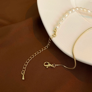 Close-up of freshwater pearl and gold snake chain necklace with lobster clasp