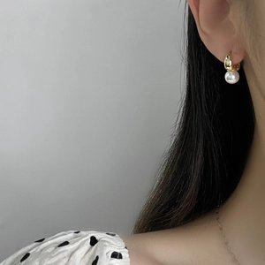 Side view of elegant gold hoop pearl earrings worn by a model for a minimalist look