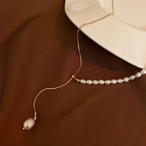 Detail of elegant freshwater pearl necklace with gold snake chain and slider clasp