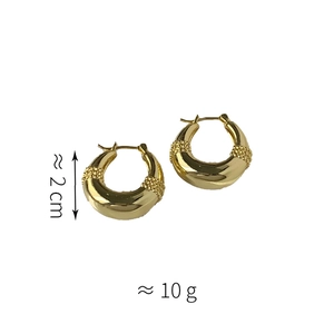 Detailed view of hollow gold drop earrings with textured relief and 2cm diameter size