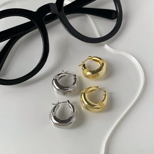 Polished gold and silver hollow hoop earrings with beaded texture on white background