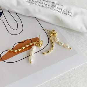 Elegant gold drop earrings with baroque pearls and beaded chain on minimalist card