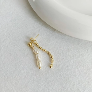 Macro shot of 18K gold plated double chain earrings with pearls and metallic beads