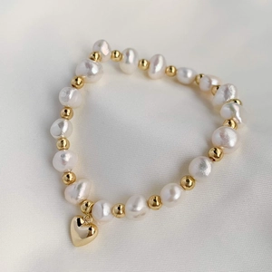 Baroque freshwater pearl heart bracelet with gold plating on white silk background